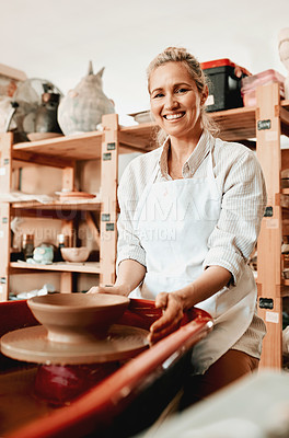 Buy stock photo Shot of a female artisan working in her pottery workshop