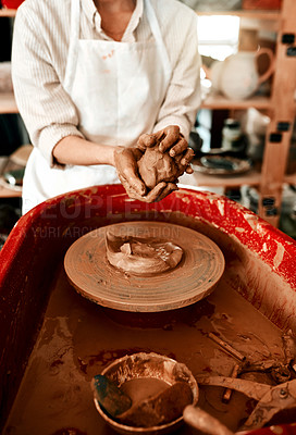 Buy stock photo Cropped shot of an unrecognizable woman molding clay on a pottery wheel