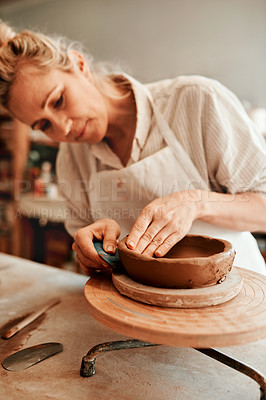 Buy stock photo Cropped shot of a woman shaping a clay pot in her workshop