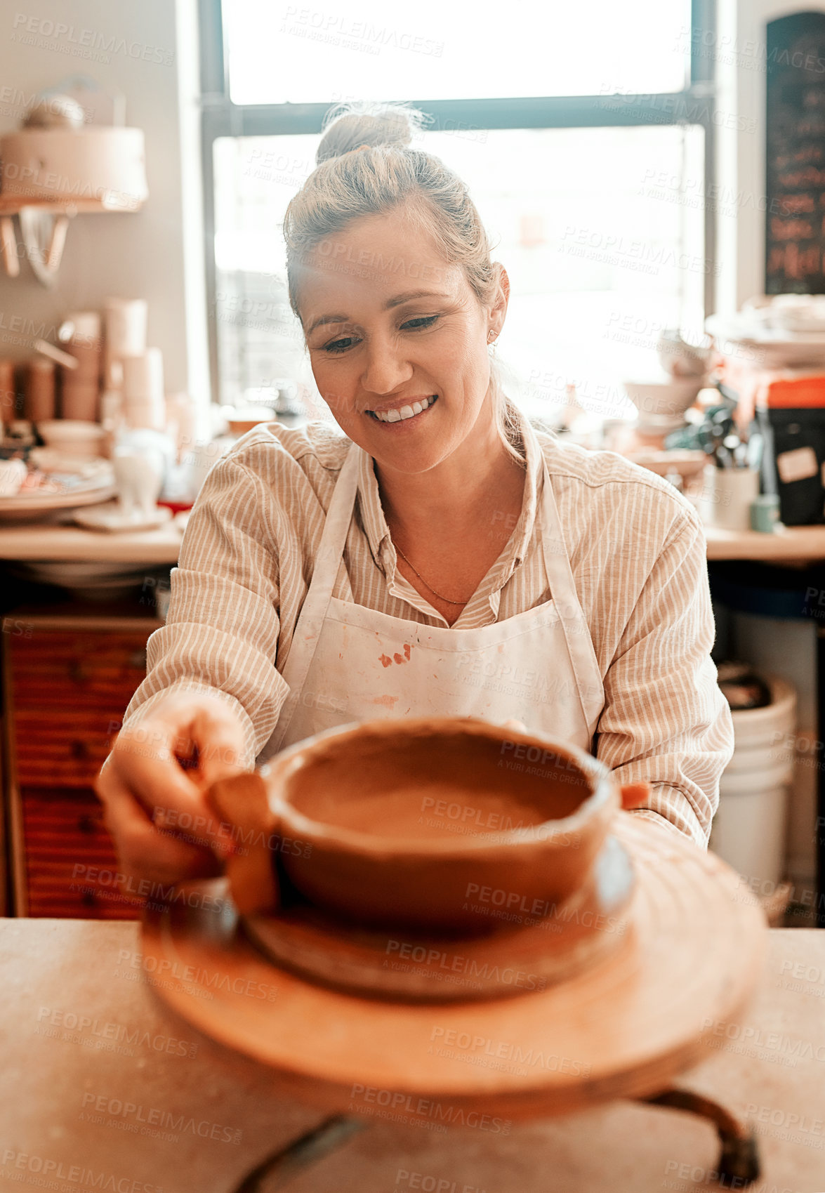 Buy stock photo Woman, clay and smile in workshop by pottery wheel for craft, inspiration and production at small business. Person, artist and entrepreneur for eco friendly material, sculpture and happy in studio