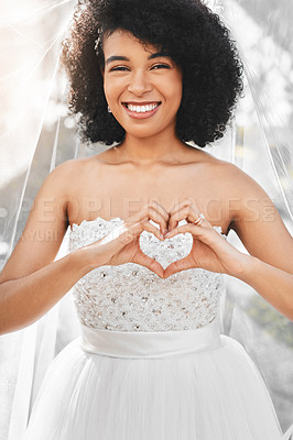 Buy stock photo Portrait of a happy and beautiful young bride making a heart shape with her hands outdoors on her wedding day