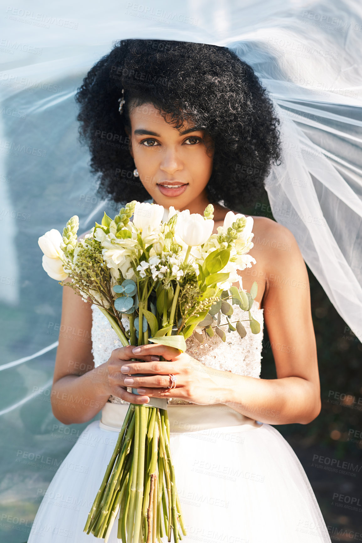 Buy stock photo Portrait of a happy and beautiful young bride holding a bouquet of flowers while posing outdoors on her wedding day