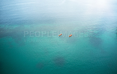 Buy stock photo High angle shot of two adventurous young couples canoeing together in the beautiful oceans of Indonesia