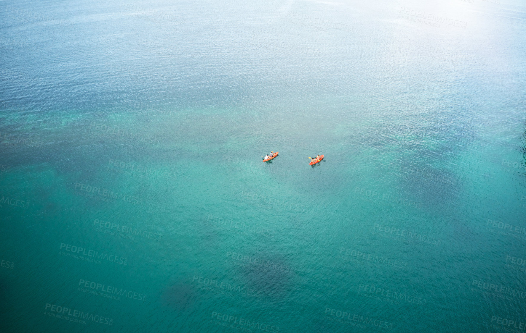 Buy stock photo High angle shot of two adventurous young couples canoeing together in the beautiful oceans of Indonesia