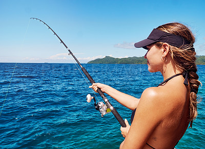 Buy stock photo Cropped shot of an attractive young woman fishing out at sea