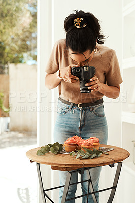Buy stock photo Cropped shot of an attractive young businesswoman standing and using her camera to photograph cupcakes for her blog