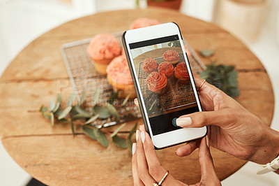 Buy stock photo Cropped shot of an unrecognizable businesswoman using her cellphone to take pictures of cupcakes for her blog