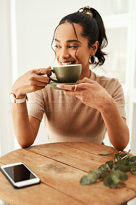 Buy stock photo Cropped shot of an attractive young woman sitting alone in her home and enjoying a cup of coffee