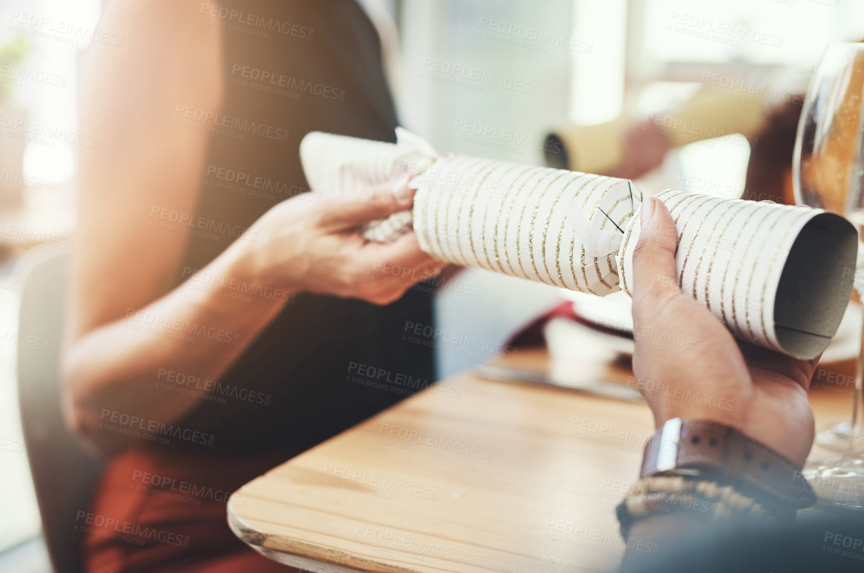 Buy stock photo Christmas, people and hands with crackers for celebration at dinner table with party, holiday and social gathering. Decoration, friends and gift in home with bonding, lunch and traditional present
