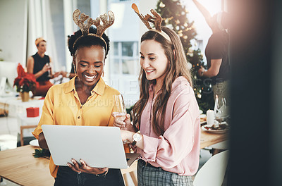 Buy stock photo Cropped shot of two attractive young girlfriends smiling while using a laptop together on Christmas day at home