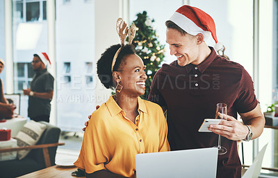 Buy stock photo Cropped shot of a cheerful young couple smiling while using a laptop together on Christmas day at home