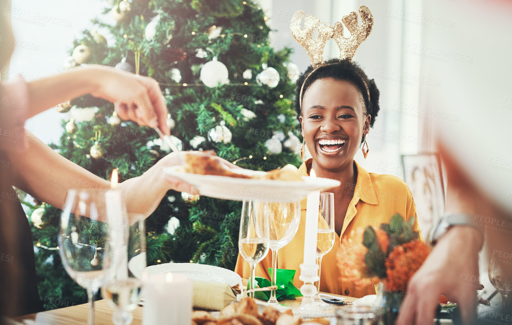 Buy stock photo Cropped shot of an attractive young woman smiling while having Christmas lunch with her friends at home