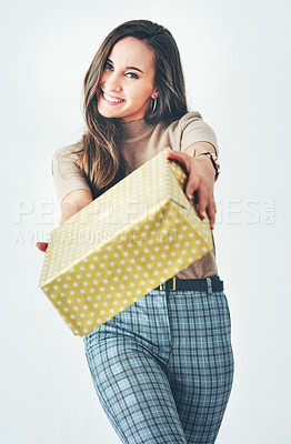 Buy stock photo Portrait of an attractive young woman holding a wrapped present against a grey background