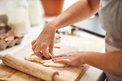 Buy stock photo Cropped shot of an unrecognizable woman cutting out cookies in her kitchen