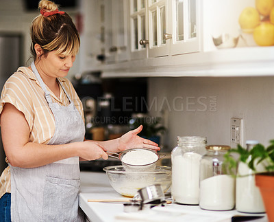Buy stock photo Cropped shot of a woman sifting flour into a glass bowl