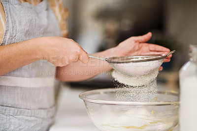 Buy stock photo Cropped shot of a woman sifting flour into a glass bowl