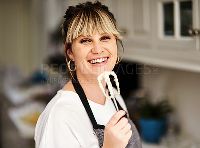 Buy stock photo Cropped shot of a beautiful young woman baking at home