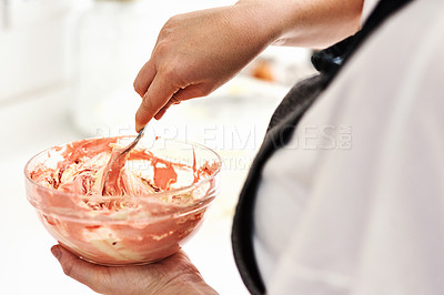 Buy stock photo Cropped shot of an unrecognizable woman mixing icing in a glass bowl