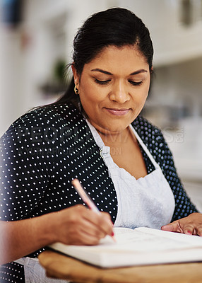 Buy stock photo Cropped shot of a making notes while wearing a apron