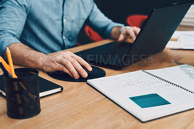 Buy stock photo Cropped shot of an unrecognizable male architect using a laptop while working in his office