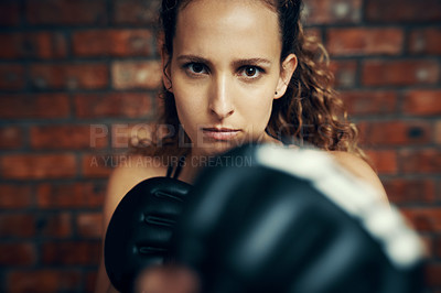 Buy stock photo Cropped portrait of a female kick boxer practicing at the gym