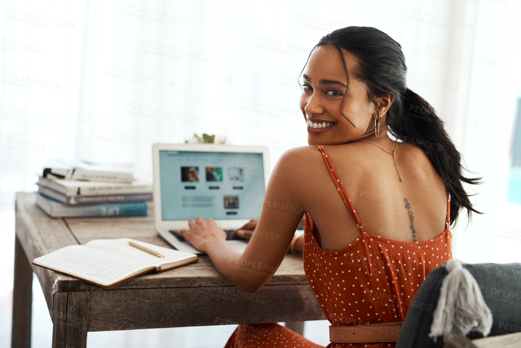 Buy stock photo Cropped portrait of an attractive young businesswoman sitting in her home office and using her laptop