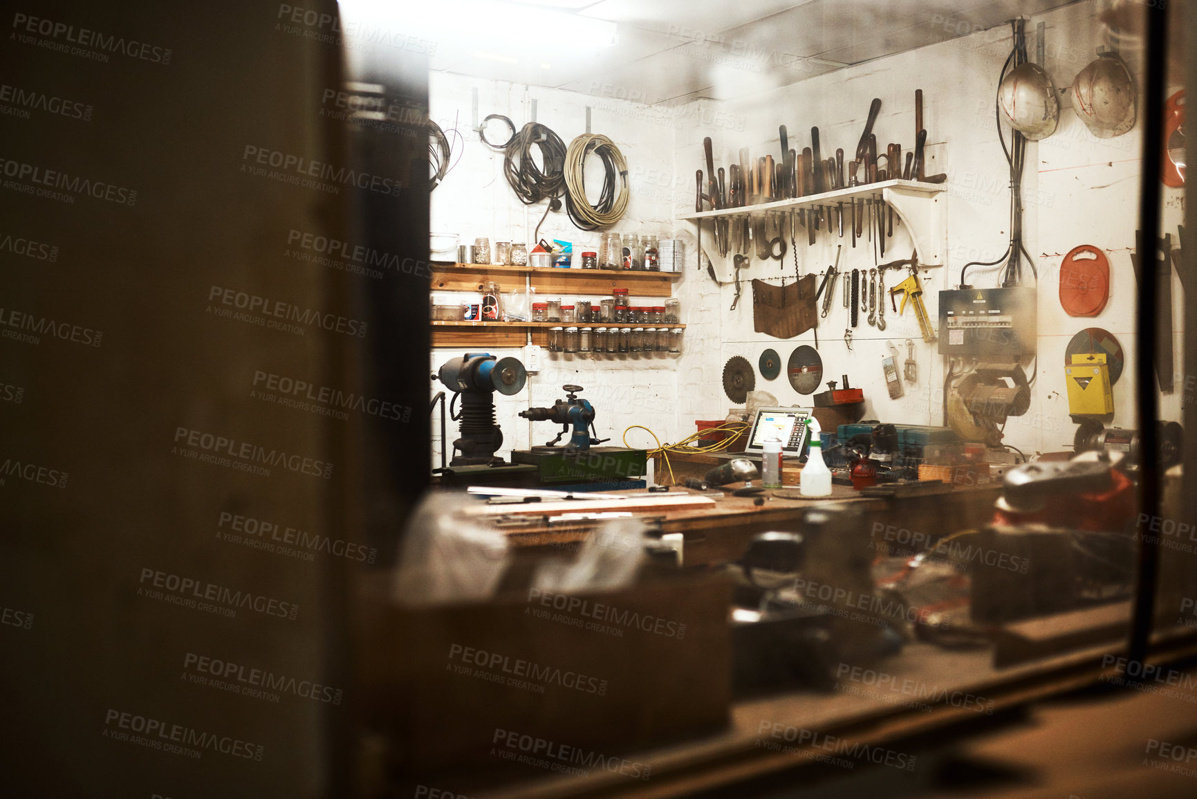Buy stock photo Shot of a workshop filled with different types of tools inside someone's home at night
