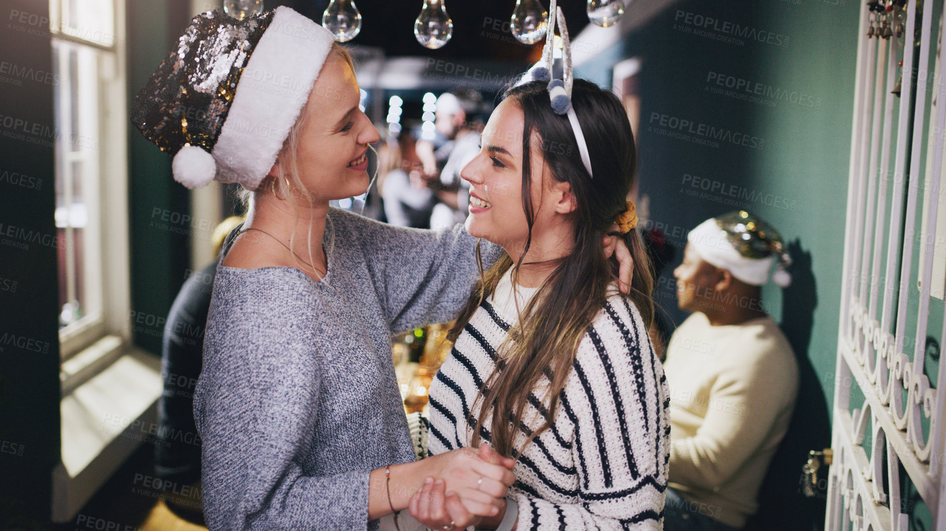 Buy stock photo Lesbian couple, dance and Christmas party in home or festive celebration. Event, love and romance of women dancing face to face, holding hands and celebrating holiday together in house with friends.