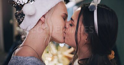 Buy stock photo Shot of a happy young couple kissing during a Christmas party at home