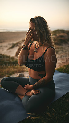 Buy stock photo Full length shot of an attractive young yogi sitting alone and putting pressure on the third eye pressure point
