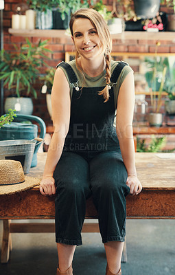 Buy stock photo Cropped portrait of an attractive young businesswoman sitting alone in her flower shop during the day