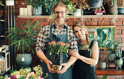 Buy stock photo Cropped portrait of two young business owners standing in their floristry together while holding a bouquet of roses