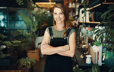 Buy stock photo Cropped portrait of an attractive young business owner standing in her floristry alone with her arms folded