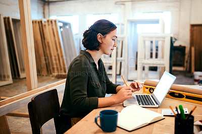 Buy stock photo Shot of a female carpenter using a laptop in her workshop