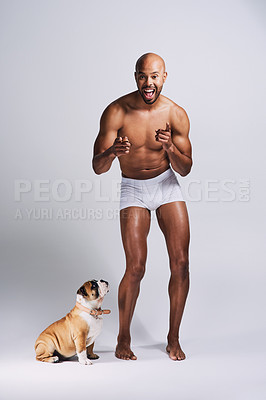 Buy stock photo Full length shot of a handsome young man posing with his adorable puppy against a grey background