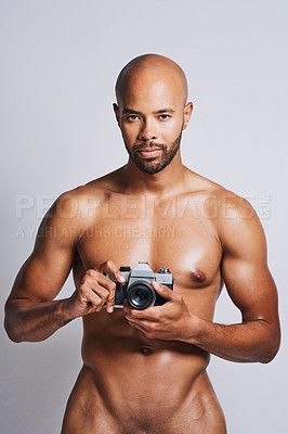 Buy stock photo Portrait of a naked young man taking pictures with a camera against a grey background