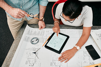 Buy stock photo High angle shot of two unrecognizable architects using a digital tablet while working together in a modern office