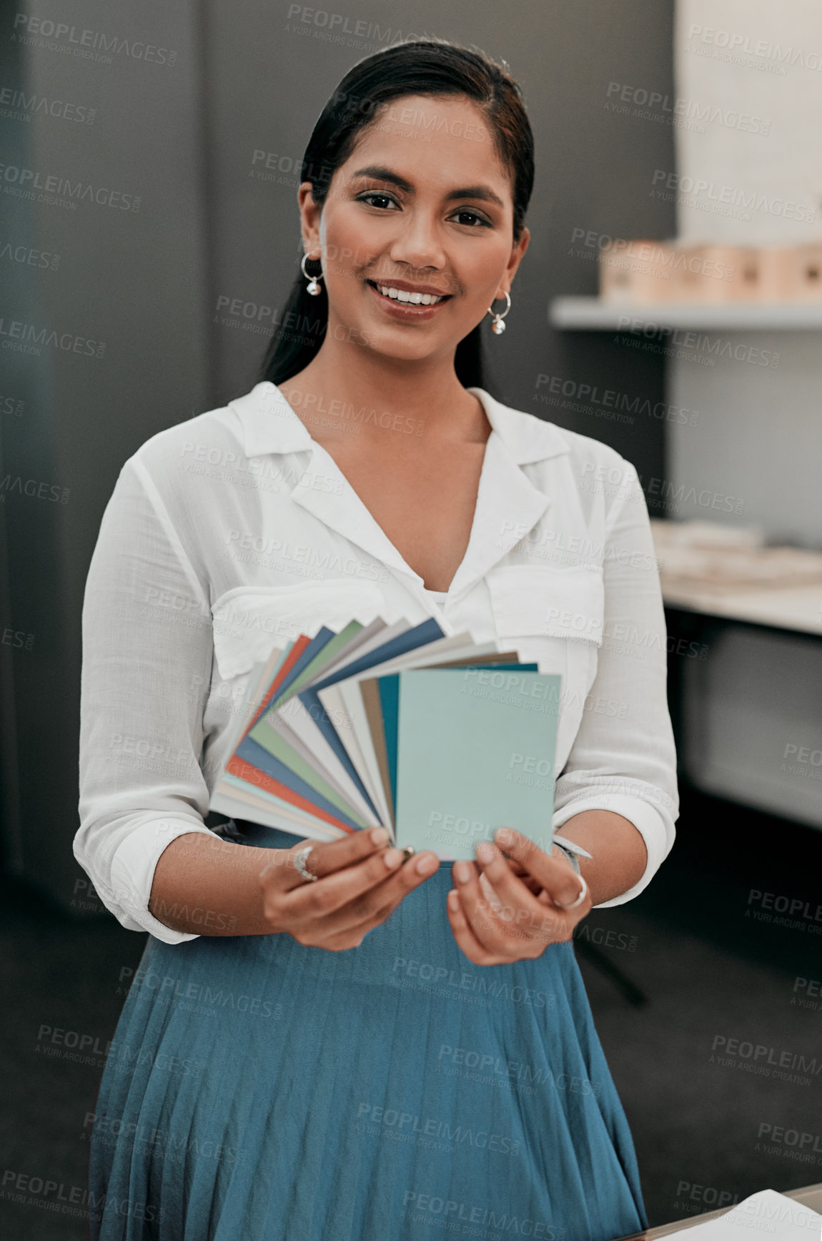 Buy stock photo Cropped shot of a young architect looking at a color swatch while standing in her office