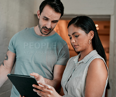 Buy stock photo Cropped shot of two young designers looking at something on a digital tablet