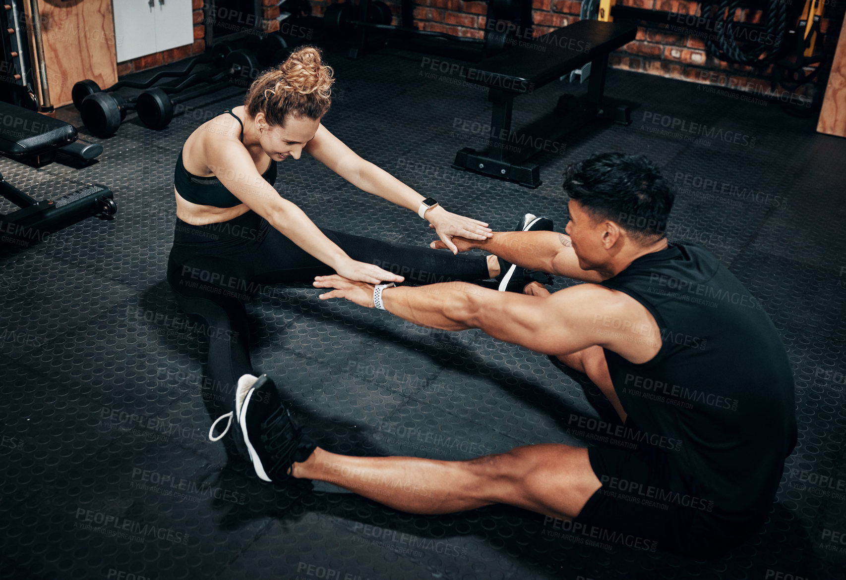 Buy stock photo Shot of two sporty young people working out together at the gym