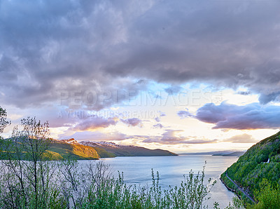 Buy stock photo Scenic view of a lake, ocean or sea with cloudy sky at sunset and copy space.Uncultivated trees, bushes, shrubs around a bay of water in Norway. Landscape of calm, serene, peaceful, quiet nature pond