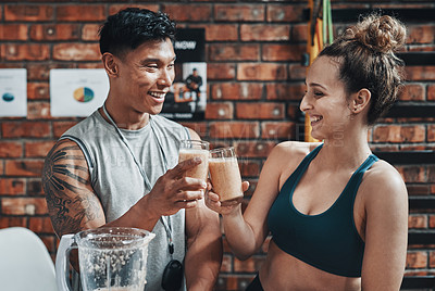 Buy stock photo Cropped shot of two young sportspeople making a toast with milkshakes while working in a gym