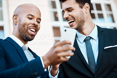 Buy stock photo Cropped shot of young handsome businessmen using a cellphone together outside