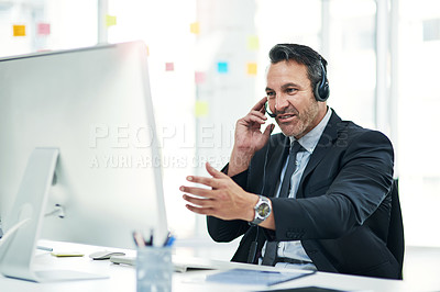 Buy stock photo Shot of a mature businessman using a headset while working on a computer in an office