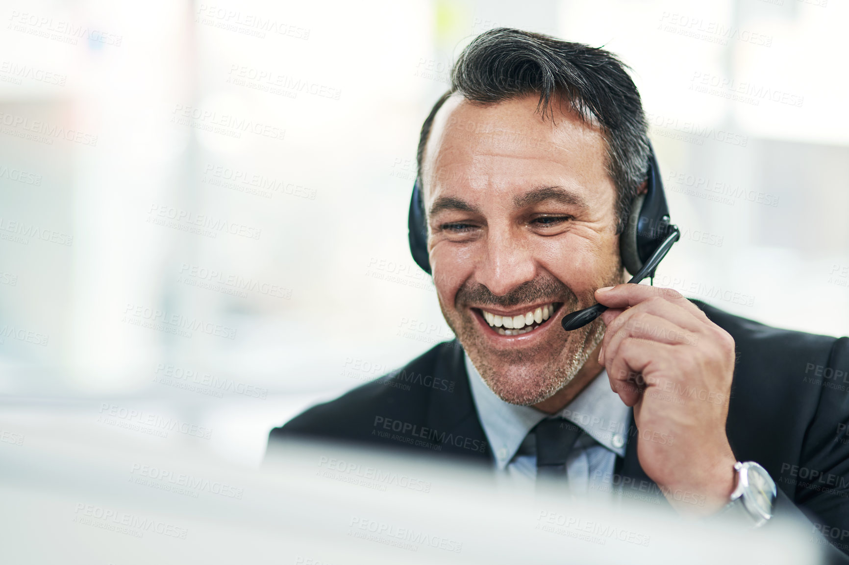 Buy stock photo Shot of a mature businessman using a headset while working on a computer in an office