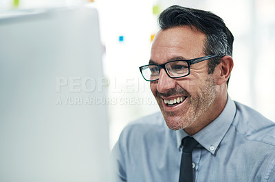 Buy stock photo Shot of a mature businessman working on a computer in an office