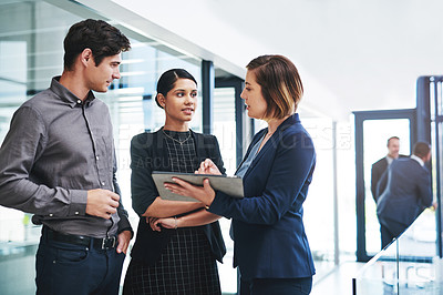 Buy stock photo Cropped shot of a group of young businesspeople having a discussion while standing in a modern office