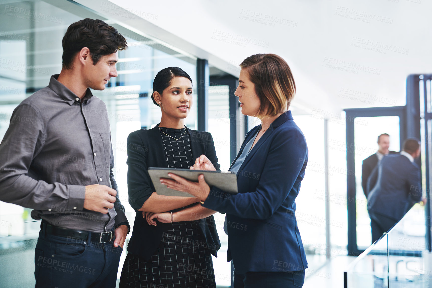 Buy stock photo Cropped shot of a group of young businesspeople having a discussion while standing in a modern office