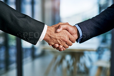 Buy stock photo Cropped shot of two unrecognizable businesspeople shaking hands in a modern office