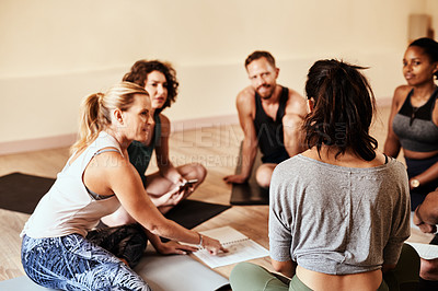 Buy stock photo Shot of a group of young men and women chatting during a yoga class